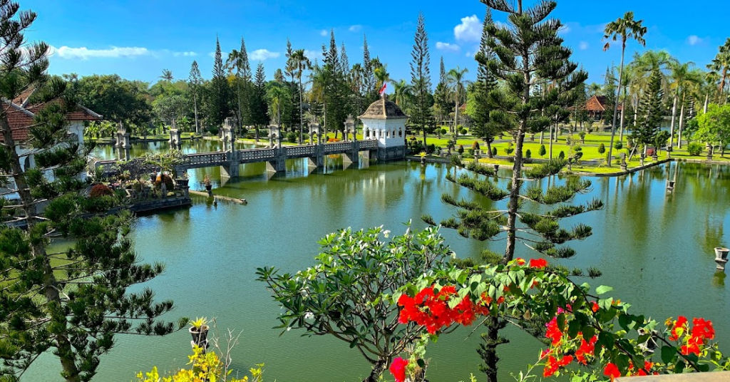 aman Ujung Water Palace with majestic pavilions, ponds, and lush gardens under a blue sky