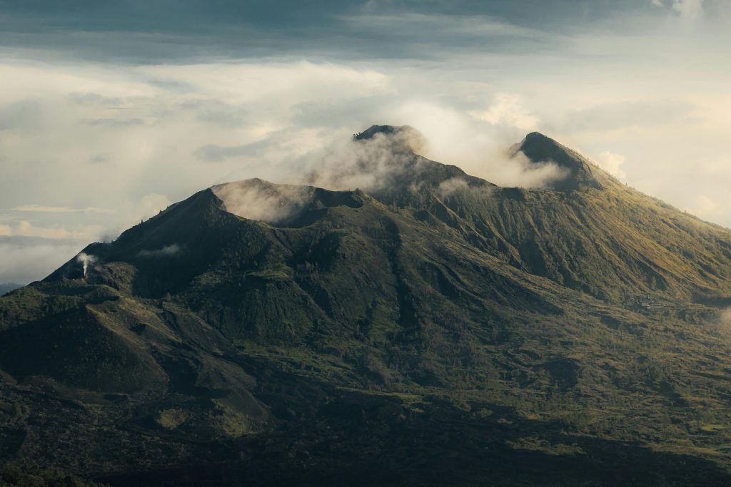 Hikers trekking up Mount Batur at sunrise with scenic mountain views